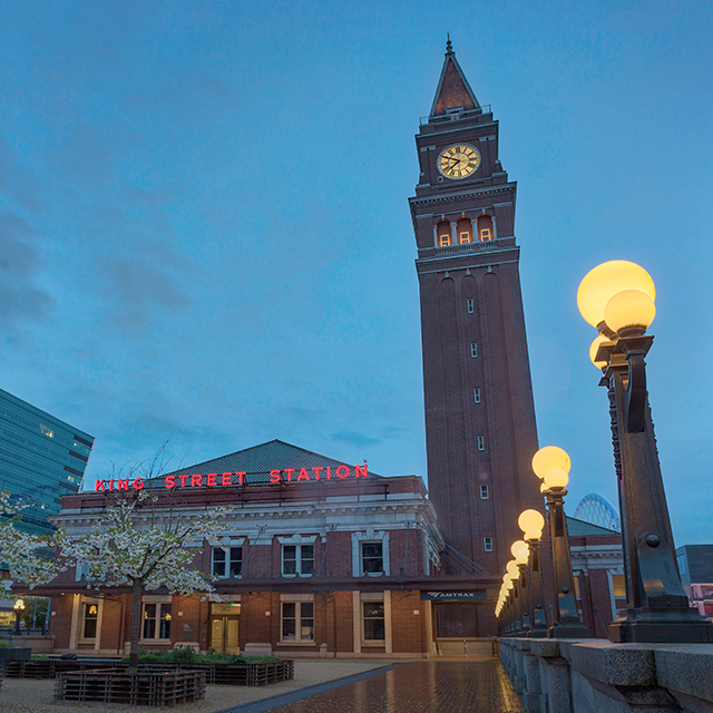 The red brick Seattle King Street station features a clock tower with pyramidal roof.