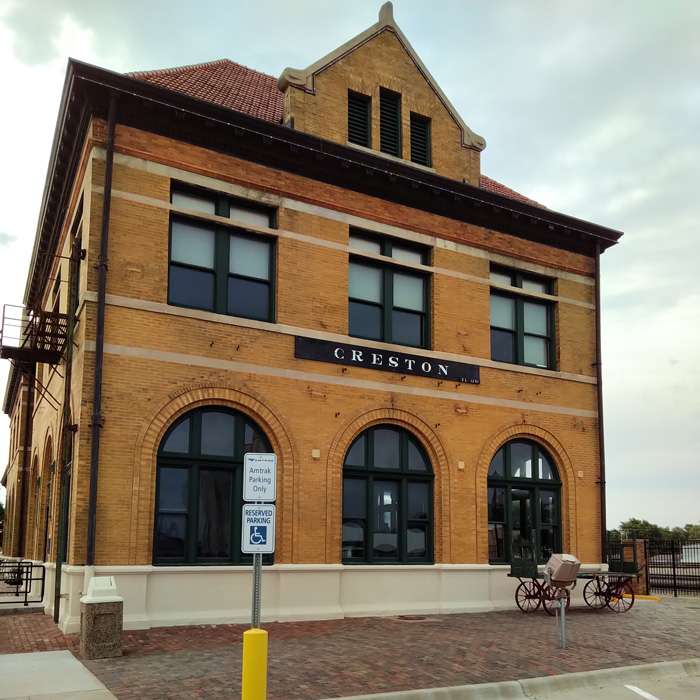Two story buff brick railroad station.