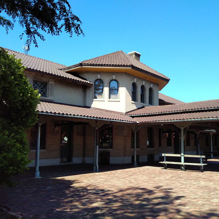 Two story brick train depot with arcade.