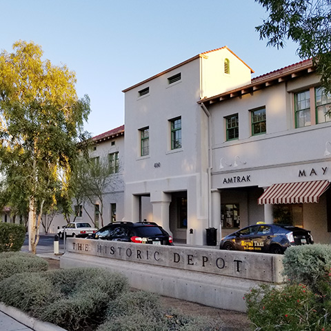 Tucson depot showing cars parked in front and a garden.