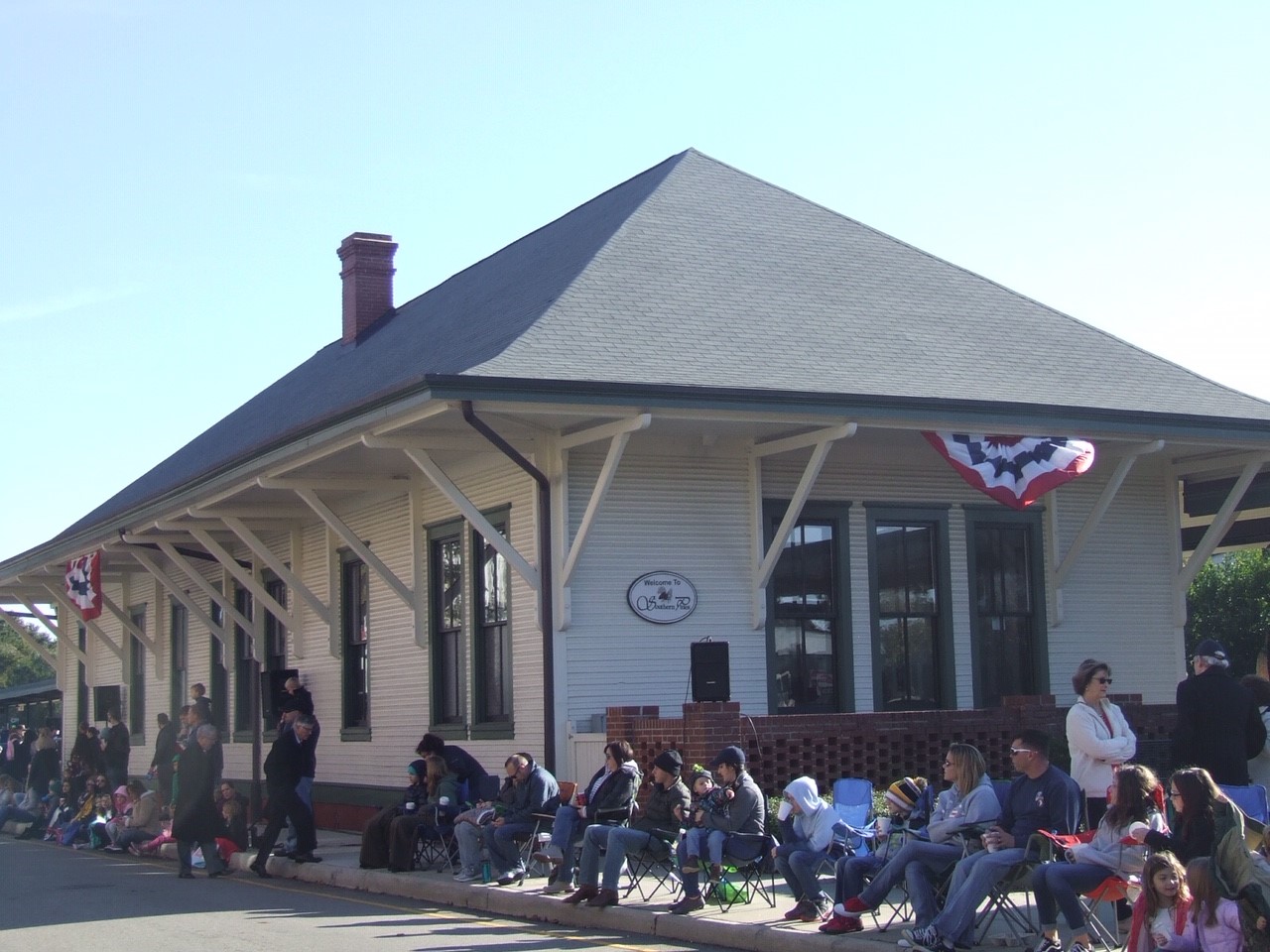 Crowd in front of the Southern Pines depot for a parade.