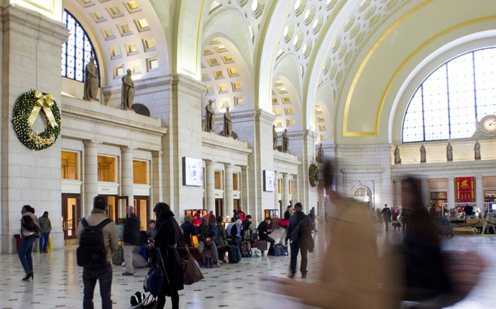 People walking through a large, brightly lighted hall.