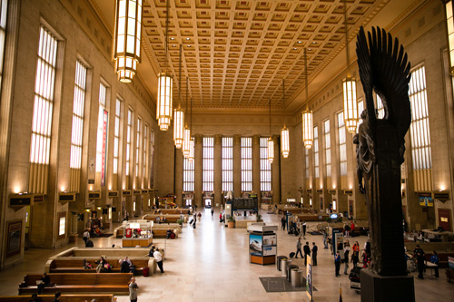 Main Concourse of Gray 30th Street Station showing large windows and chandeliers.
