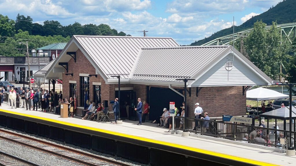 A brick railroad station with a concrete platform.